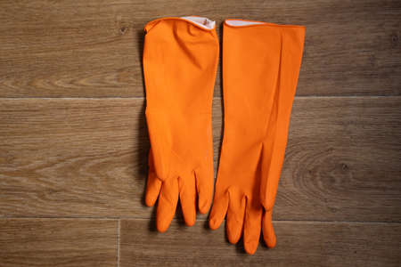 orange rubber gloves lie on the table close-up