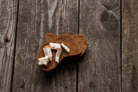 black slice of bread with bacon on a wooden table for lunchの写真素材