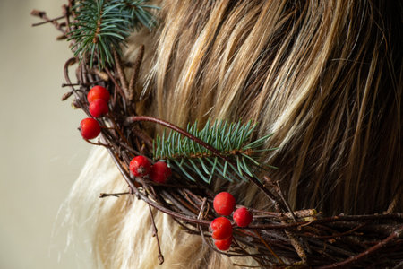 close-up of a Christmas wreath of viburnum branches and a Christmas tree on the girl's headの写真素材