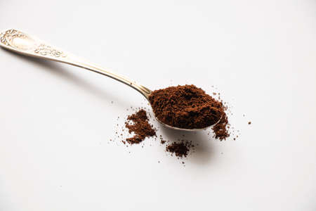 spoon of ground roasted coffee on isolated white backgroundの写真素材