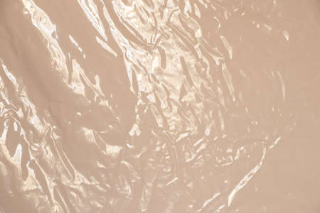 light beige glossy crumpled film as background for designの写真素材