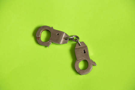 iron handcuffs on a green background close upの写真素材