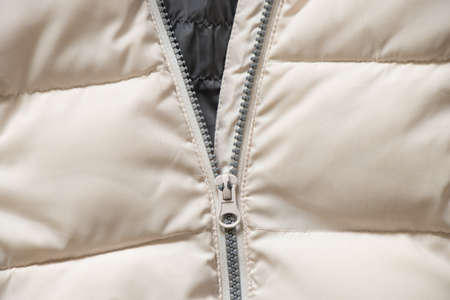 white winter women's padded jacket with zipper as background close-up