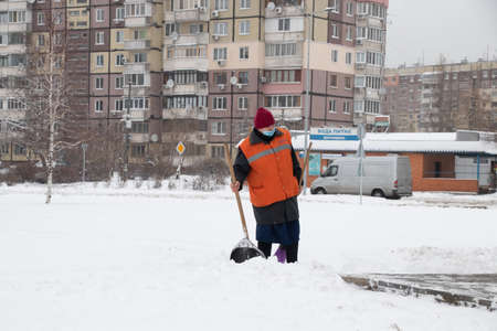 Ukraine Dnipro 13.01.2021 - woman cleans the road from snow in January in a residential area of the cityのeditorial素材