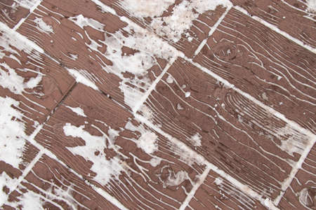 paving slabs in parks made under a tree brown in the snow in winter as a backgroundの写真素材