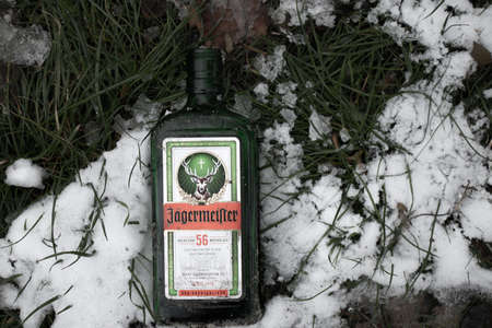 Ukraine Dnipro 23.11.2020 - an empty bottle of jagermeister lies on the snow on the grass in the forest in autumn, rest in natureのeditorial素材
