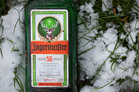 Ukraine Dnipro 23.11.2020 - an empty bottle of jagermeister lies on the snow on the grass in the forest in autumn, rest in natureのeditorial素材