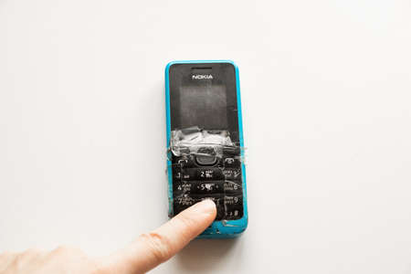 Ukraine Dnipro 28.12.2020 - The old push-button telephone of Nokia lies on a white table in working orderのeditorial素材