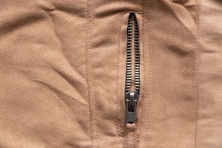 zipper on brown fabric as background close-upの写真素材