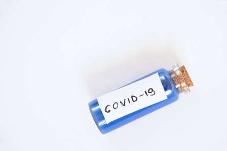 glass test tube with a label and the inscription covid-19 on it onの写真素材
