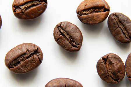 roasted whole grains of coffee on white background macro photoの写真素材