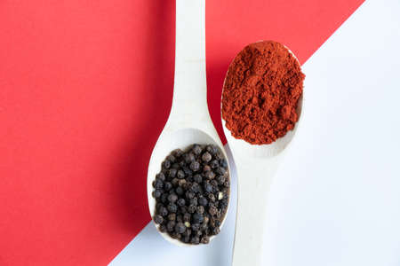 wooden spoons with different types of spices and peppers on an isolated background close-upの写真素材