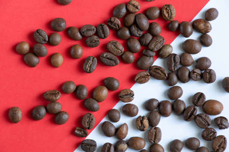 roasted coffee beans on a red white background close upの写真素材