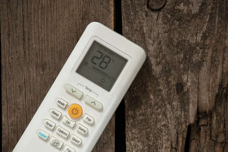 white remote control from air conditioner on wooden background close upの写真素材