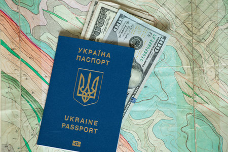 Ukrainian international passport and American dollars lie on a geographic mapの写真素材