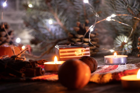 on the New Year's table candles garland pine branch mandarin and cinnamon with a cup, New Year's...