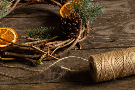 christmas wreath of vines and a ball of thread on a wooden table, christmas preparationの写真素材