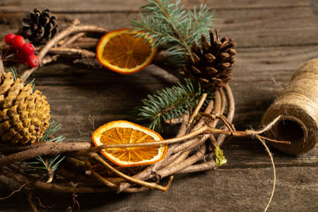 christmas wreath of vines and a ball of thread on a wooden table, christmas preparationの写真素材