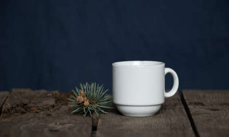 a cup of coffee and a nearby pine branch on a wooden background, new year decorの写真素材
