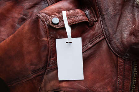 sale on white price tags, which lies on a red leather jacket, sale of clothesの写真素材