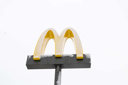 Ukraine Dnipro 08.03.2021 - McDonald's logo in the snow against the sky close up