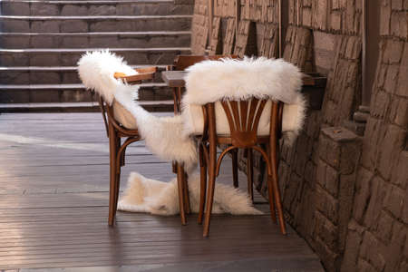wooden chairs with white fur blankets in an empty room, wooden furniture, dormitory decorの写真素材