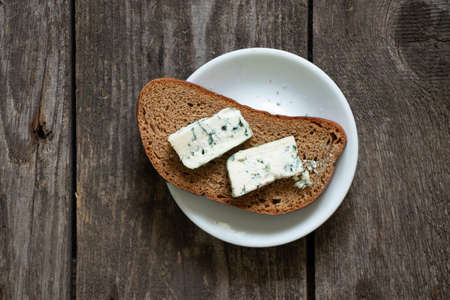 a piece of blue cheese on a wooden table close-up