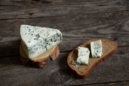 a piece of blue cheese on a wooden table close-upの写真素材