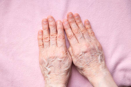 hands of an elderly woman close up on isolated backgroundの写真素材