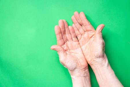 hands of an elderly woman close up on isolated backgroundの写真素材