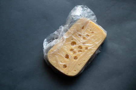 piece of hard cheese on isolated colored background close upの写真素材