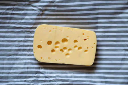 piece of hard cheese on isolated colored background close upの写真素材