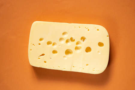 piece of hard cheese on isolated colored background close upの写真素材
