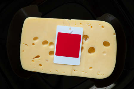 a piece of hard cheese on a black background close-up