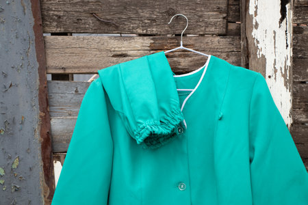 old medical suit hanging on a hanger on the wall in the street in Ukraine, nurse uniformの写真素材