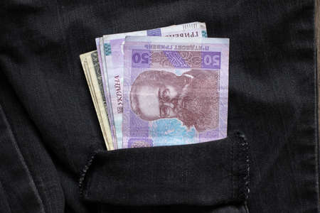 50 UAH lie in a denim pocket of black pants close-up, Ukrainian money