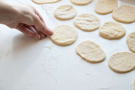 female hands knead raw dough on a white table in the kitchen, doughの写真素材