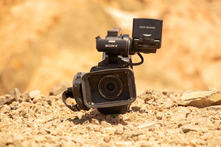 Egypt Sharm El Sheikh 04/26/2021 - Sony video camera lies on the sand in the desert in the sun, the...