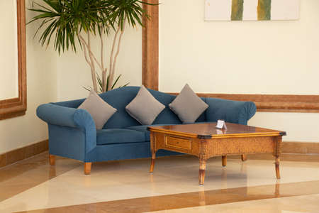 a blue soft sofa and a coffee table in the hall in the living room of a hotel in egypt laid the...
