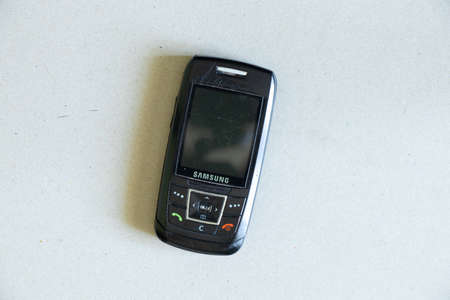 Ukraine Dnipro 21.05.2021 - Old push-button sliding phone Samsung on isolated background close-upのeditorial素材