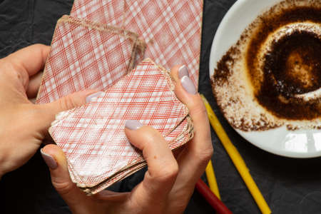 coffee grounds in the hands of a fortune teller and cards and candles on the table, fortune telling...