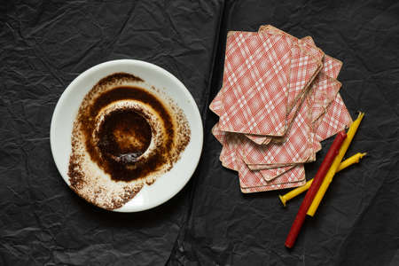 coffee grounds in a saucer and cards and candles on the table, fortune telling and prediction, fortune telling by coffee grounds, fortune tellerの写真素材