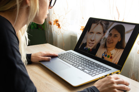 a girl from home communicates with a laptop via video communication, video communication on a laptop computer, webcam, video chatの写真素材