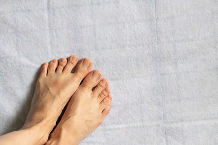 legs of a naked young girl on a white floor, female legs on an isolated background