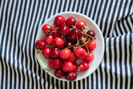 ripe red cherries on a striped backgroundの写真素材