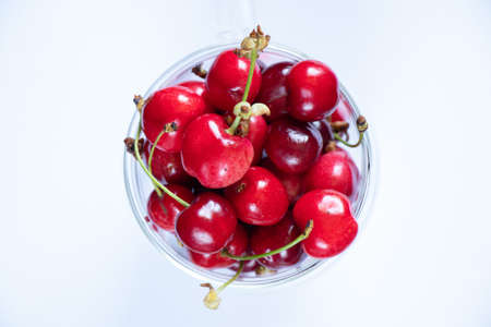 full cup with cherries, sweet cherries in a cup on the tableの写真素材