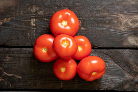 ripe red tomatoes on an old wooden tableの写真素材