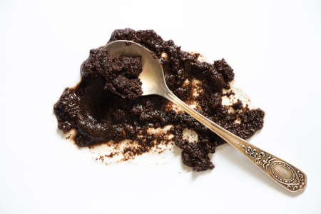 spilled coffee grounds on a white background and a teaspoon lies next to it, a coffee stainの写真素材