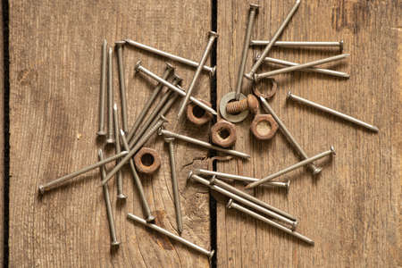 old rusty nails and nuts on the wooden floor, repair and constructionの写真素材