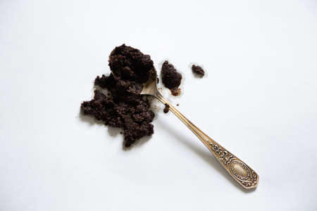 spilled coffee grounds on a white background and a teaspoon lies next to it, a coffee stainの写真素材